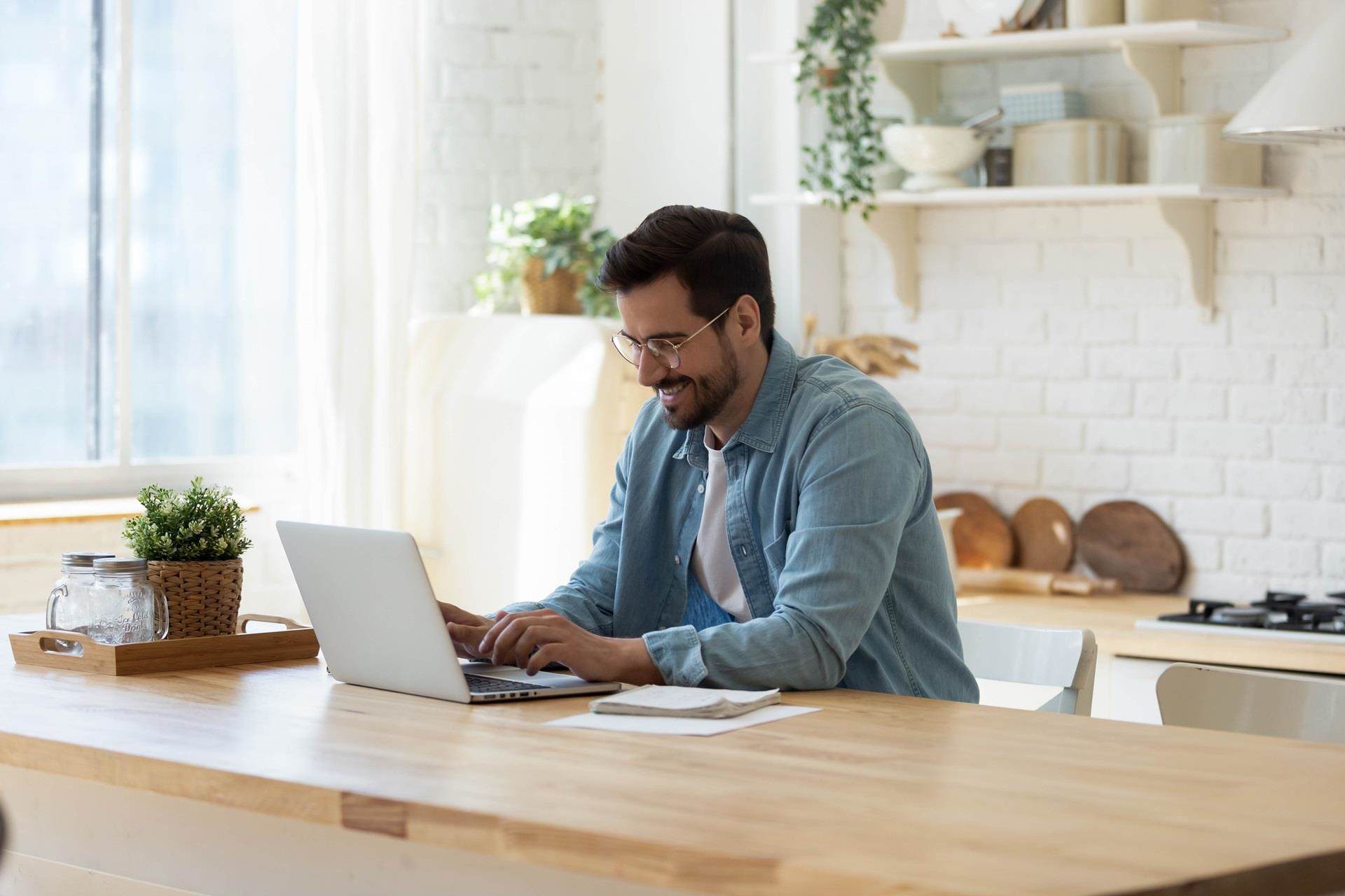 Man looking at his laptop in the kitchen